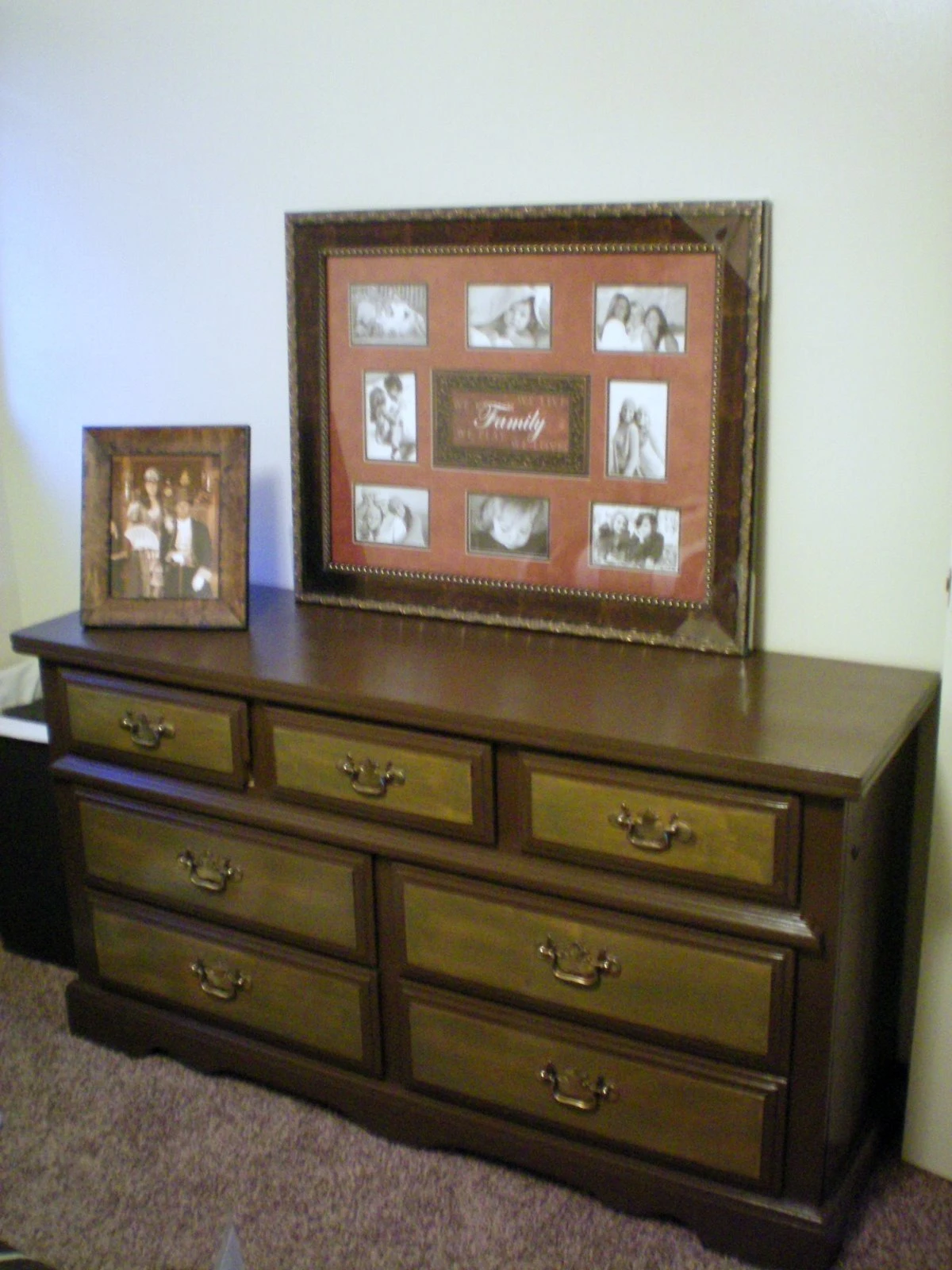 The finished dresser inside the bedroom with a dark wood stain, topped with a large ornate "Family" photo collage frame and a smaller family portrait frame