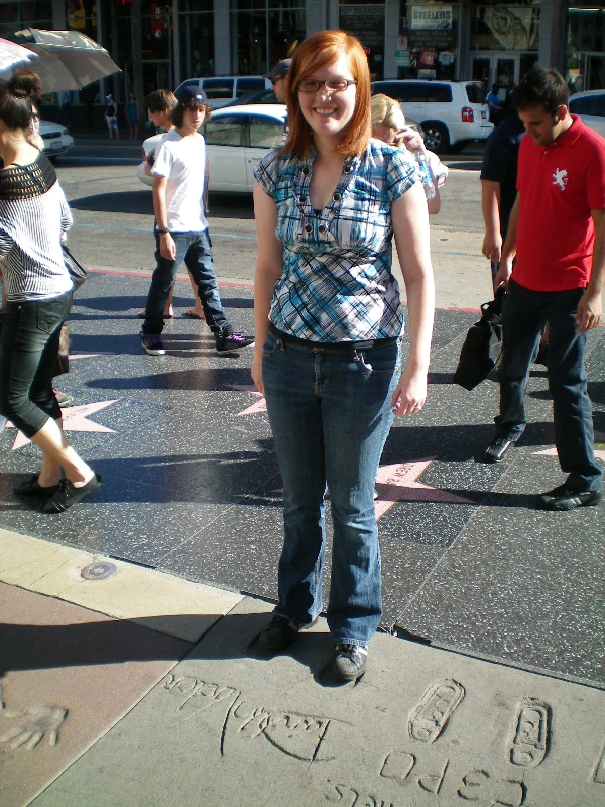 Danielle standing on the Hollywood Walk of Fame near C-3PO's footprints cast in cement, tourists and stars visible around her